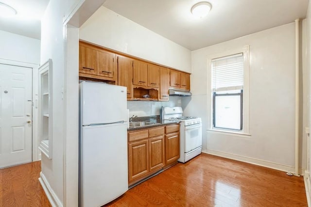 kitchen featuring sink, white appliances, and hardwood / wood-style flooring