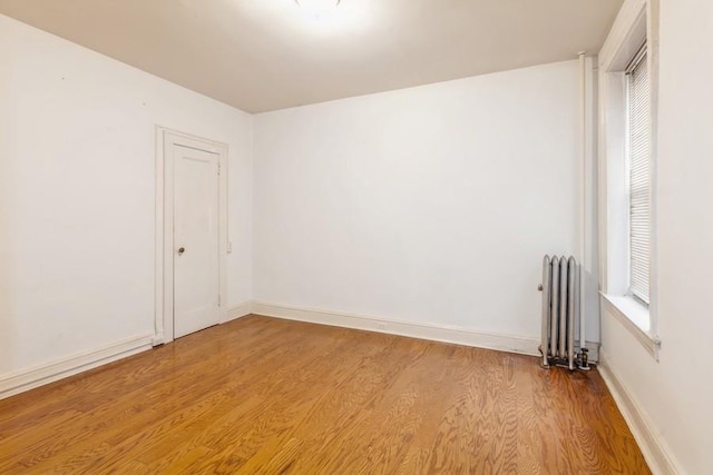 empty room with radiator and light hardwood / wood-style flooring