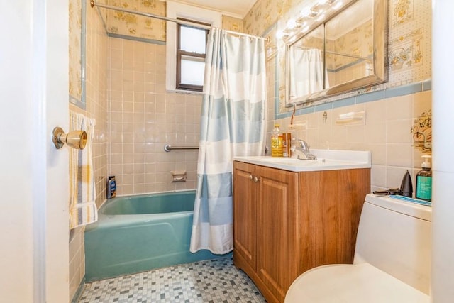 full bathroom featuring tile patterned flooring, toilet, shower / bath combo with shower curtain, vanity, and tile walls