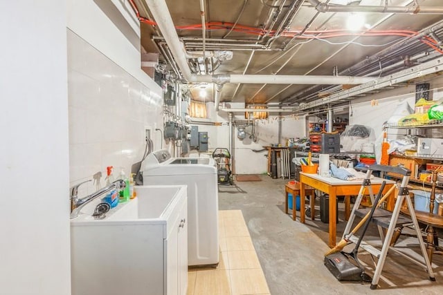 basement featuring washer and clothes dryer and sink