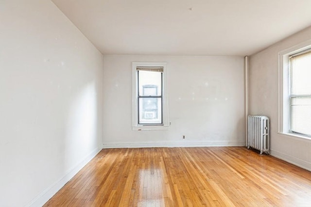 unfurnished room featuring light hardwood / wood-style floors and radiator