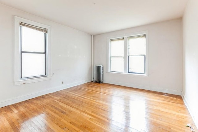 unfurnished room with light wood-type flooring and radiator