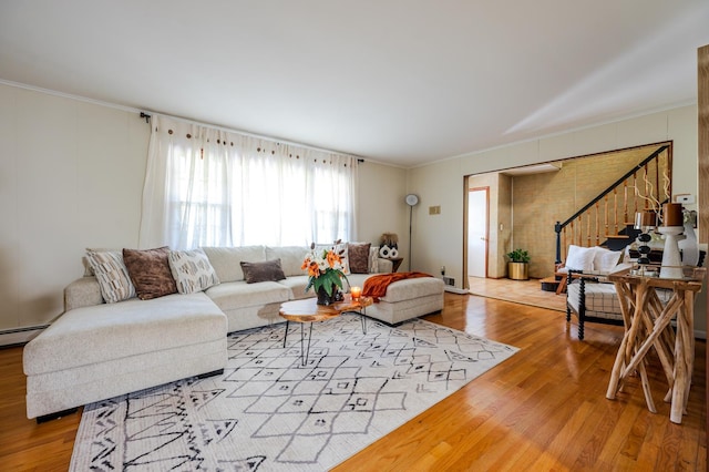 living room featuring crown molding, light hardwood / wood-style floors, and a baseboard radiator