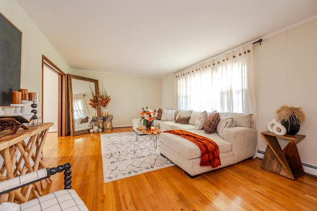 living room with hardwood / wood-style floors, ornamental molding, and a baseboard heating unit