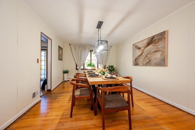 dining area featuring light hardwood / wood-style floors and ornamental molding