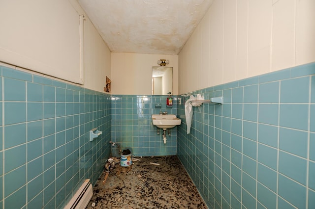 bathroom featuring sink and tile walls