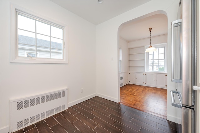 unfurnished room with radiator and dark wood-type flooring