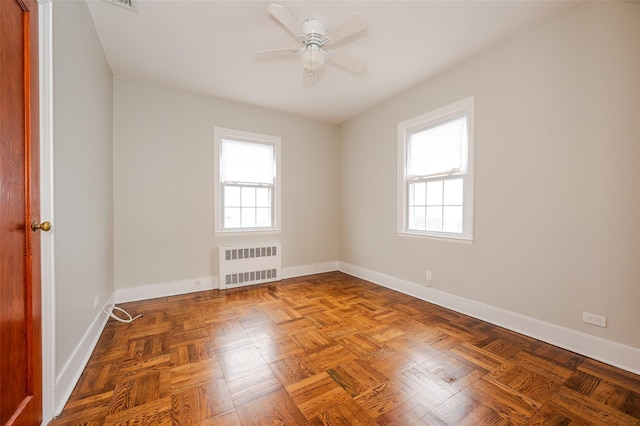 unfurnished room featuring parquet floors, radiator, and ceiling fan