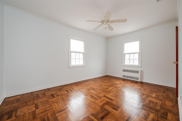 spare room with dark parquet flooring, radiator, ornamental molding, and ceiling fan