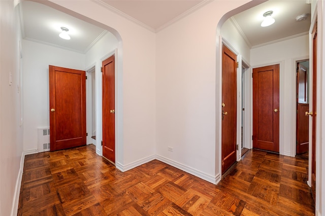 hall with dark parquet flooring and crown molding