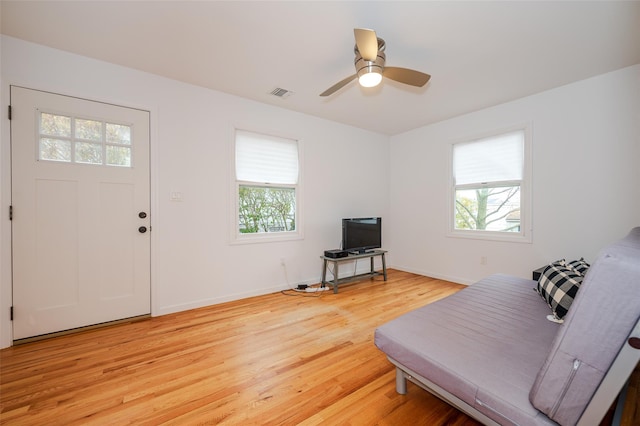 living room featuring plenty of natural light, ceiling fan, and light wood-type flooring