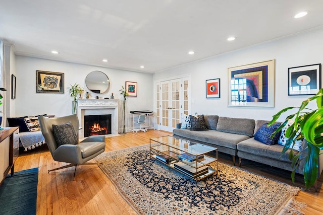 living room with crown molding, light hardwood / wood-style floors, and french doors