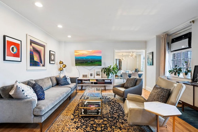 living room with crown molding, wood-type flooring, a chandelier, and a wall unit AC