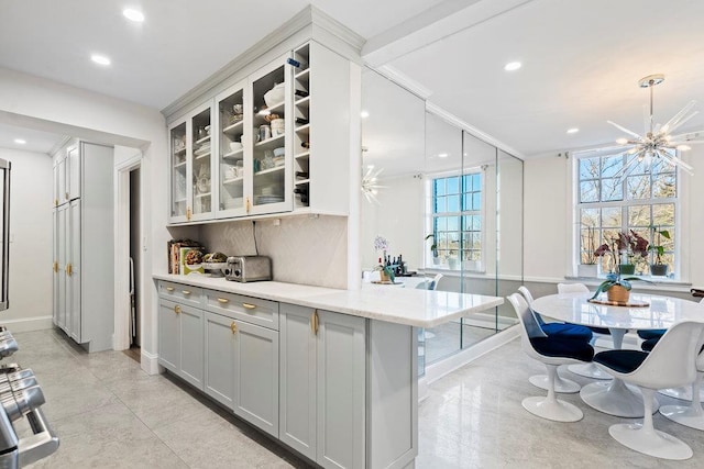 kitchen featuring a breakfast bar, pendant lighting, backsplash, and kitchen peninsula