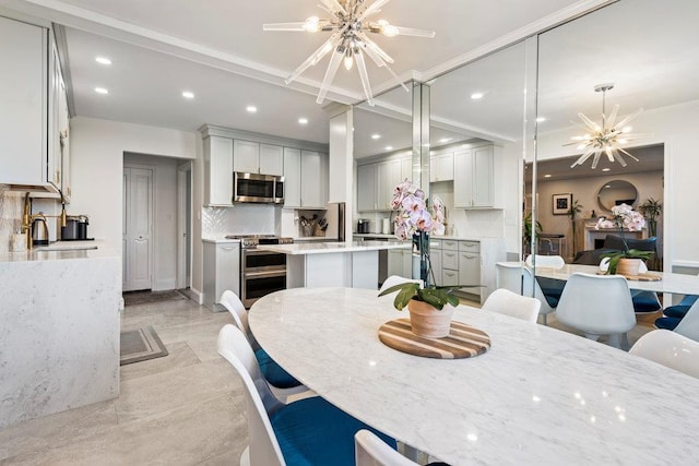 dining area with ornamental molding, sink, and an inviting chandelier