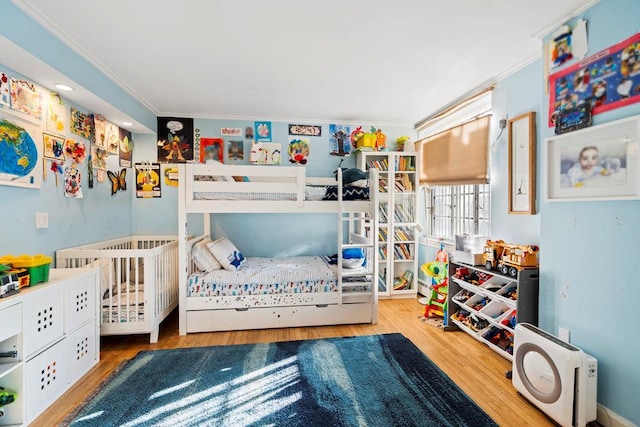 bedroom featuring wood-type flooring and crown molding