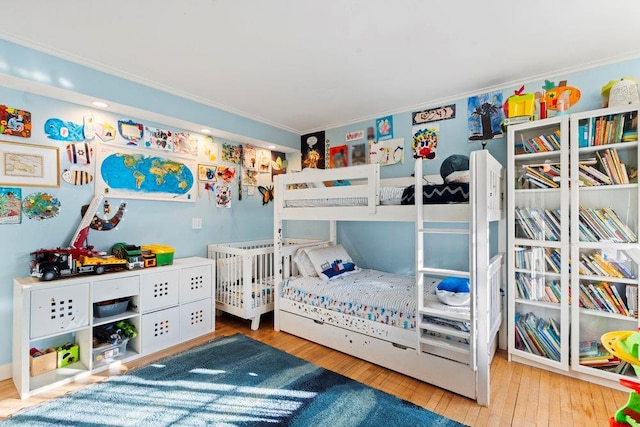 bedroom with hardwood / wood-style flooring and ornamental molding