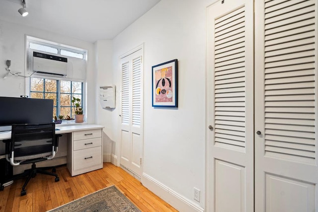 office featuring a wall mounted AC and light hardwood / wood-style floors