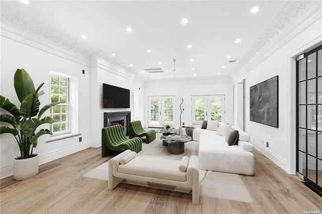 living room featuring crown molding, light hardwood / wood-style flooring, and french doors