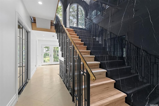 stairway featuring tile patterned flooring and french doors