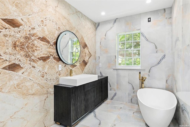 bathroom featuring vanity, tile walls, and a tub