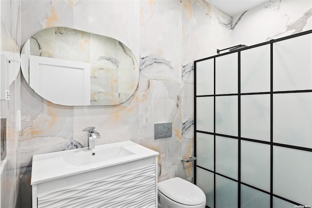 bathroom with vanity, toilet, and tile walls