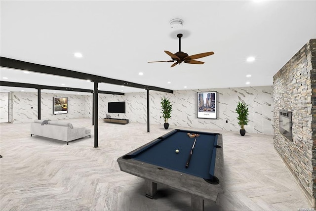 recreation room featuring light parquet floors, ceiling fan, pool table, and a fireplace