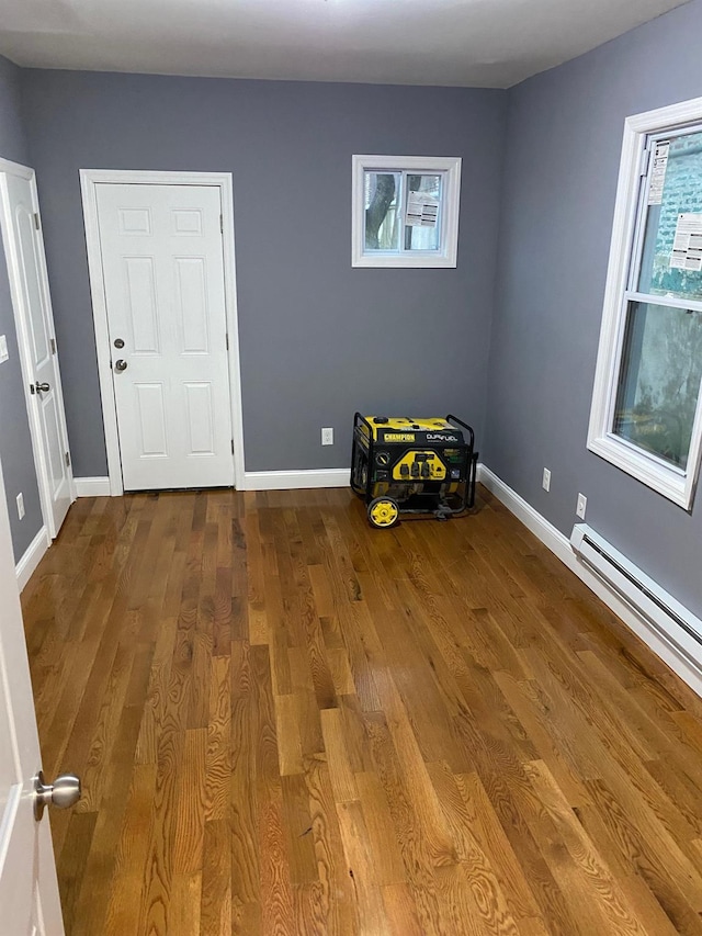 spare room featuring hardwood / wood-style flooring and baseboard heating