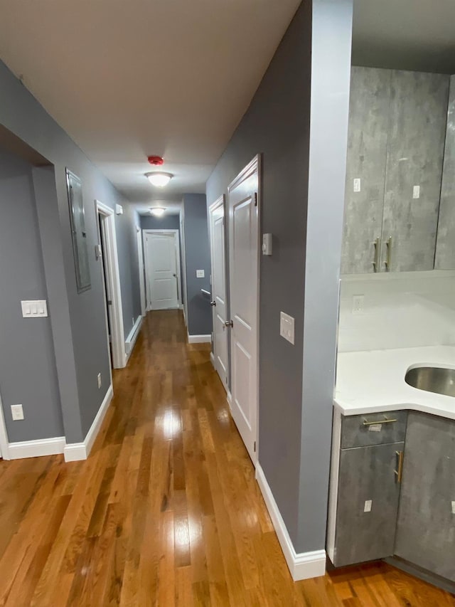 corridor with sink and wood-type flooring