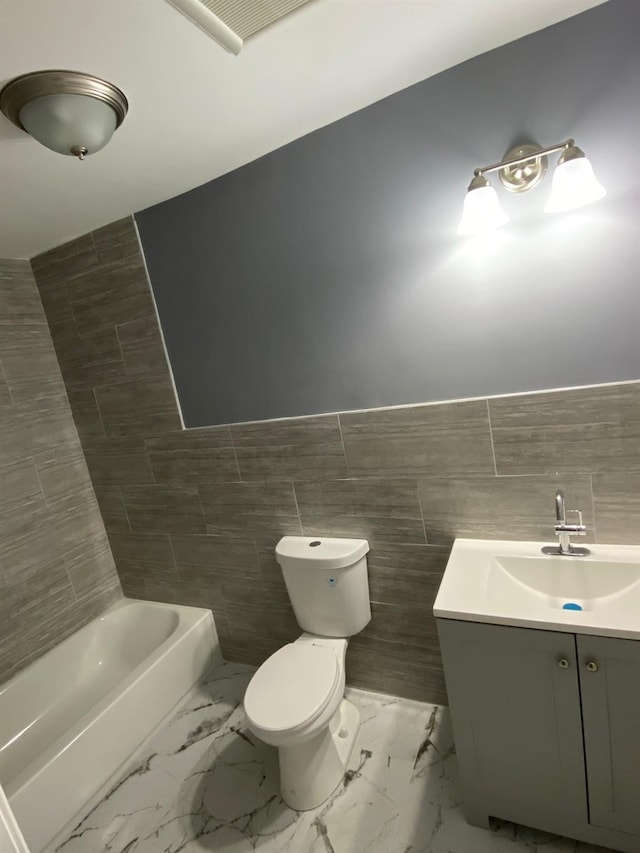 bathroom featuring vanity, a bath, toilet, and tile walls