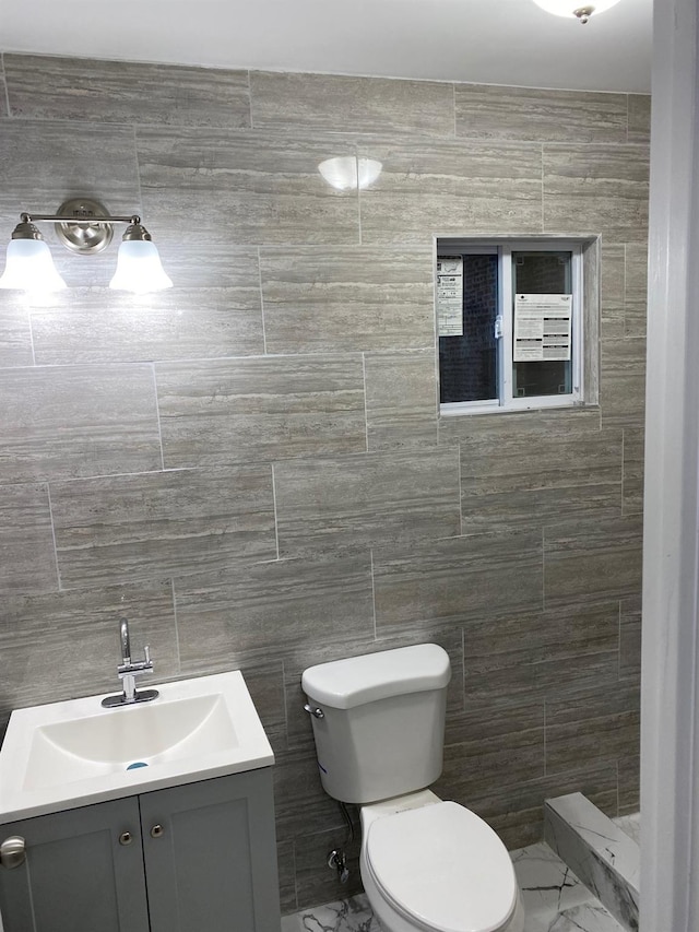 bathroom featuring vanity, toilet, and tile walls