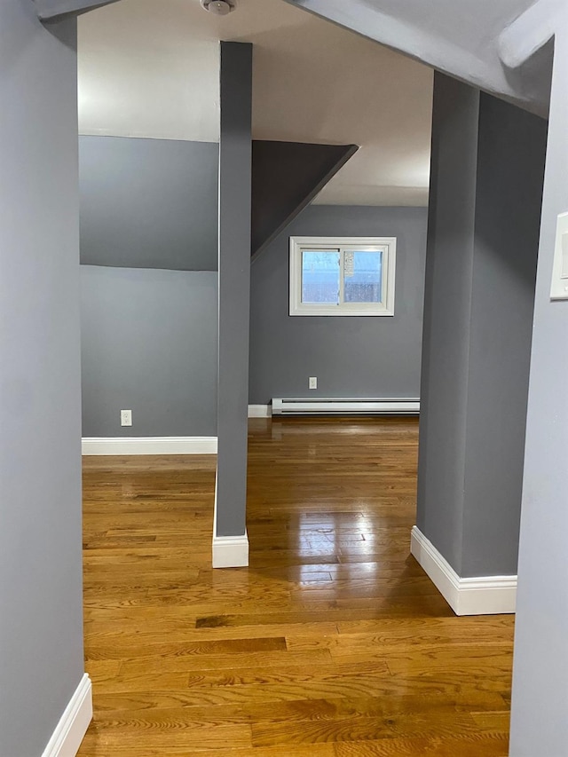 additional living space with hardwood / wood-style flooring and a baseboard radiator