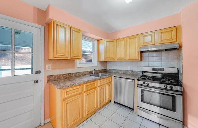 kitchen with sink, tasteful backsplash, light tile patterned floors, light brown cabinetry, and appliances with stainless steel finishes