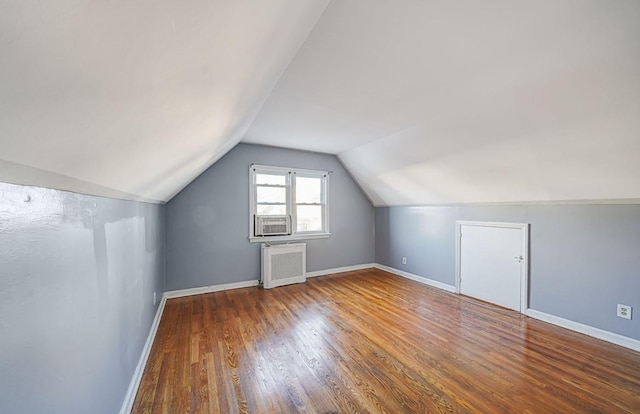 bonus room featuring hardwood / wood-style flooring, cooling unit, lofted ceiling, and radiator