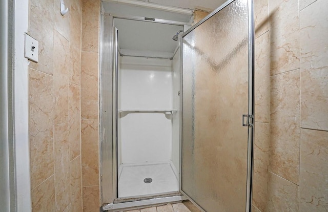 bathroom with a shower with door