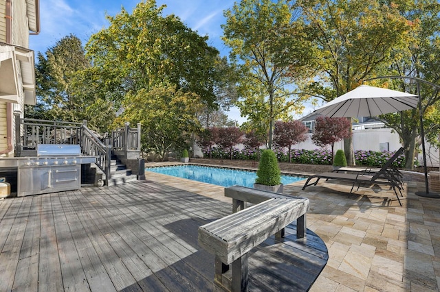 view of pool with area for grilling, a patio area, and a deck