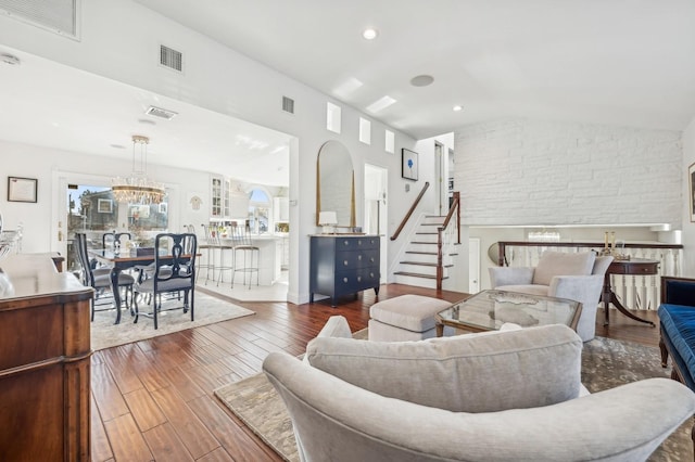 living room featuring dark wood-type flooring, lofted ceiling, and a notable chandelier