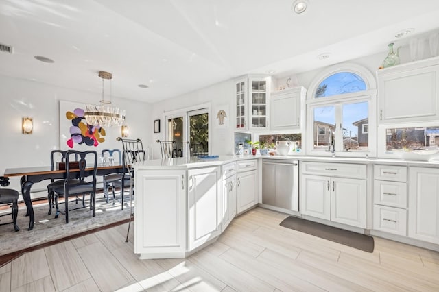 kitchen with stainless steel dishwasher, kitchen peninsula, hanging light fixtures, and white cabinets