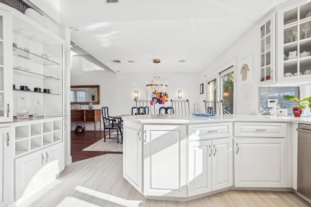 kitchen with white cabinetry, a notable chandelier, and decorative light fixtures