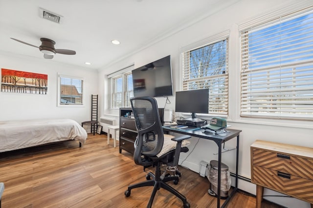 bedroom with hardwood / wood-style flooring, ornamental molding, and ceiling fan