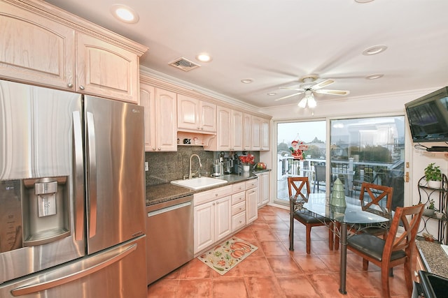 kitchen with sink, stainless steel appliances, tasteful backsplash, crown molding, and dark stone counters