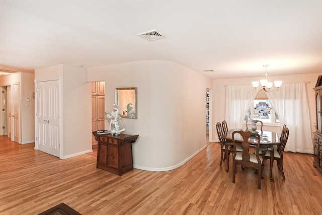 dining area featuring an inviting chandelier and light hardwood / wood-style flooring