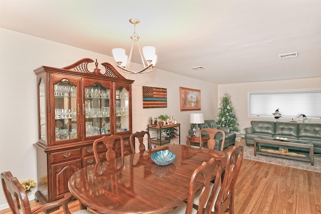 dining room with a chandelier and light hardwood / wood-style floors