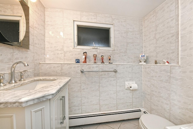 bathroom with vanity, tile patterned floors, toilet, tile walls, and a baseboard radiator