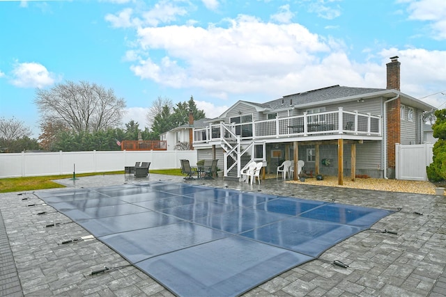 back of property featuring a patio area and a pool side deck