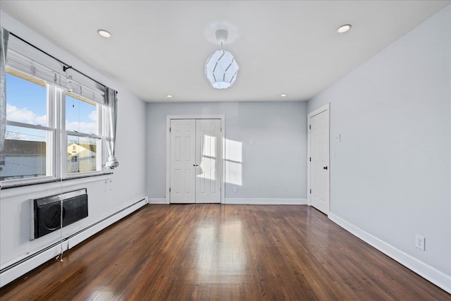 unfurnished room with dark hardwood / wood-style flooring and a baseboard radiator