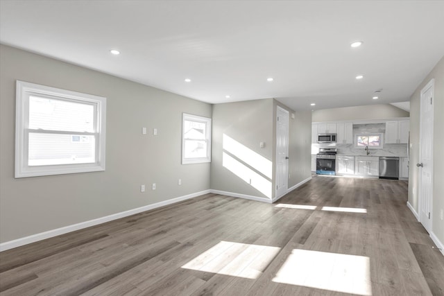 unfurnished living room featuring a fireplace, light wood-type flooring, and sink