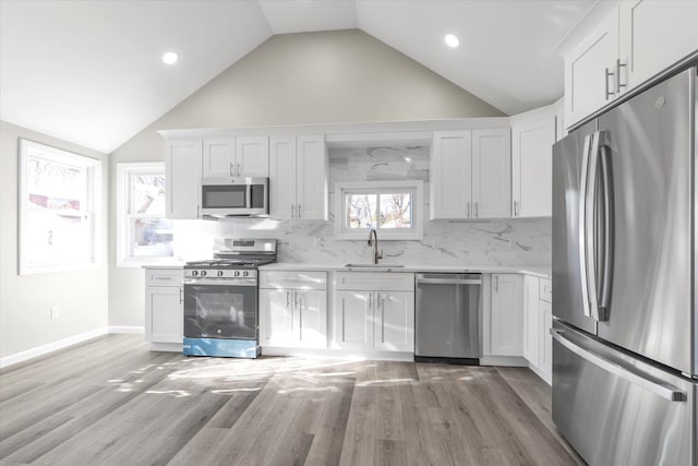 kitchen with white cabinetry, sink, light wood-type flooring, and stainless steel appliances