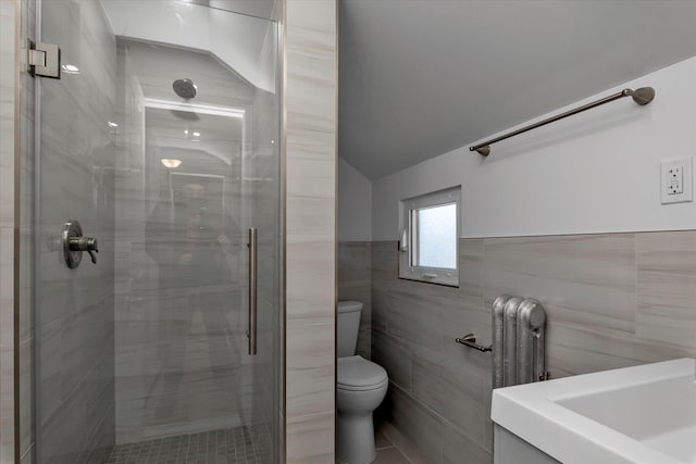 bathroom featuring walk in shower, tile walls, and toilet