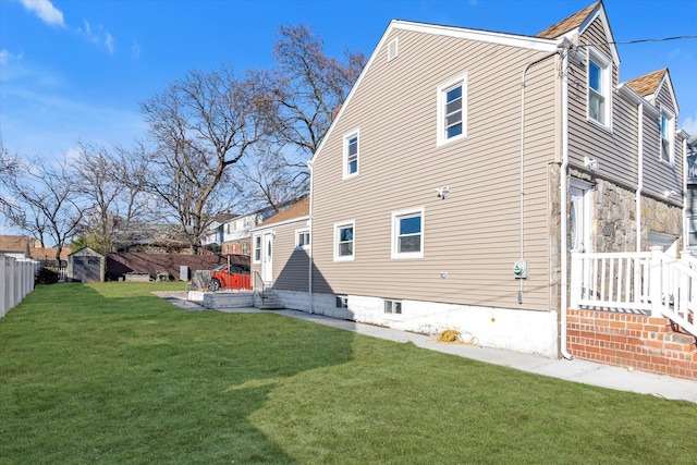 view of home's exterior with a storage unit and a lawn